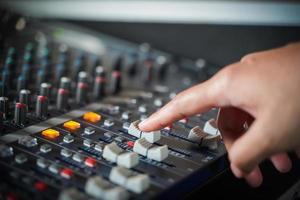 las manos de los hombres controlan la consola de un gran sistema hi-fi.con luz de estilo foto