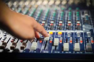 las manos de los hombres controlan la consola de un gran sistema hi-fi.con luz de estilo foto