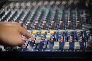 Men's hands are controlling the console of a large hi-fi system.with flair light photo