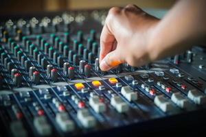 las manos de los hombres controlan la consola de un gran sistema hi-fi.con luz de estilo foto