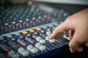 las manos de los hombres controlan la consola de un gran sistema hi-fi.con luz de estilo foto