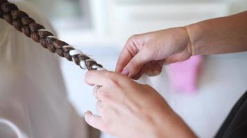 Process of braiding. Master weaves braids on head in a beauty salon, close up photo