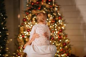 pies de un niño pequeño en el fondo de un árbol de navidad foto