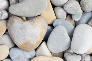 Background and texture of pebbles with a heart-shaped pebble between them photo