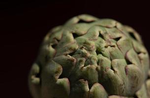 Close-up of an artichoke, against a dark background photo