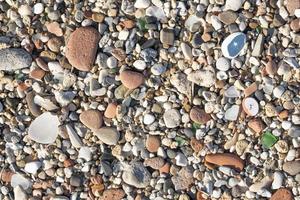 Background and texture of many round stones, cut by the sea and lying on top of each other, with cut shards in between photo