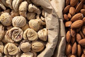 Close up and texture of dried chestnuts and almonds photographed from above in paper bags photo