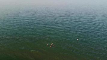 vue sur la mer à angle élevé devant la plage avec des gens à la ville de bournemouth en angleterre royaume-uni, images aériennes de l'océan britannique video