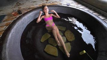 Woman relaxing in round outdoor bath. Organic skin care in hot bath photo