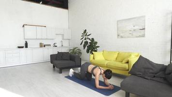 Beautiful young woman doing exercises on the floor at home photo