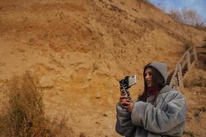 mujer joven toma una foto en un teléfono inteligente del paisaje marino