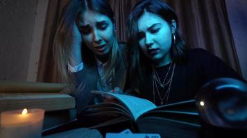 dos mujeres están leyendo un libro misterioso foto