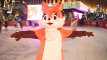 People enjoy ice skating in the street around Christmas tree in rink. photo