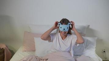 Happy sleepy young adult woman waking up lying in white bed photo