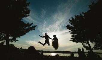 novio y novia saltando contra el hermoso cielo foto