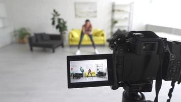 Young beautiful woman performs exercises on the camera photo