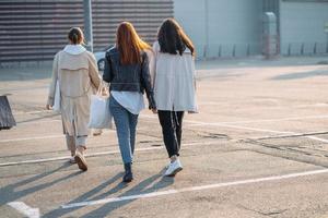 Young women with shopping bags walking on street. photo