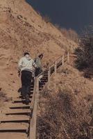 Man and woman climb the stairs together by the sea photo