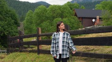 A young attractive Caucasian female stand by a fence photo