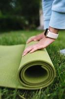 Close-up of woman folding roll fitness after working out in the park photo