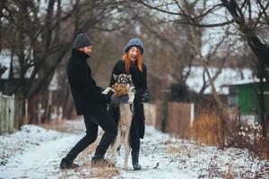 man and woman with dog walking photo