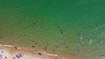 Vista de alto ângulo para o mar em frente à praia com pessoas na cidade de bournemouth, na inglaterra, reino unido, imagens aéreas do oceano britânico video