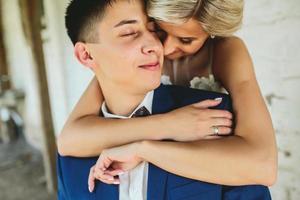 Bride embraces bridegroom photo