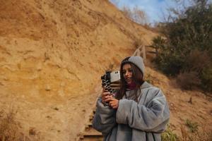 mujer joven toma una foto en un teléfono inteligente del paisaje marino