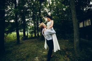 Groom lifted bride in his arms photo