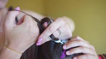 Process of braiding. Master weaves braids on head in a beauty salon, close up photo