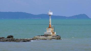 Classic vintage lighthouse or beacon in the ocean for the safety of fishing boats and fishery ship sailing in tropical sea. video