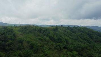 Aerial view of windmills farm for energy production on mountain with cloudy sky. Khao Kho wind turbine fields in Thailand. Wind turbines produce clean renewable energy for sustainable development. video