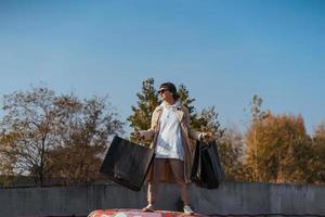 A young woman is standing in a car with bags in her hands photo