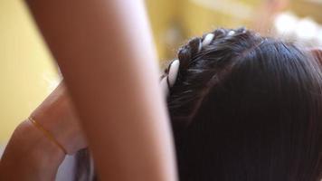 Process of braiding. Master weaves braids on head in a beauty salon, close up photo