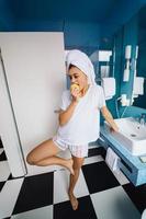 joven caucásica en el baño, sostenga la manzana. foto