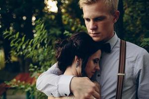 groom gently embracing his bride photo