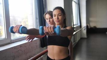 Young woman personal trainer helping with workout at gym photo