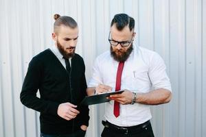 Two bearded businessman signing documents photo