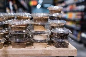 various spices and herbs packed in small transparent plastic boxes photo