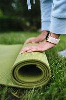 Close-up of woman folding roll fitness after working out in the park photo