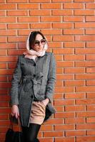 girl posing on a background of red brick wall photo