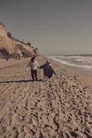 Man and woman enjoy each other, run along the seashore photo