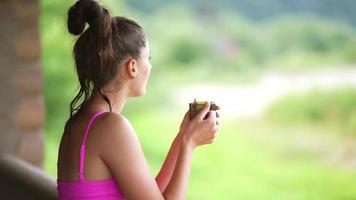 Side view portrait of a happy woman in pink swimsuit with coffee cup photo