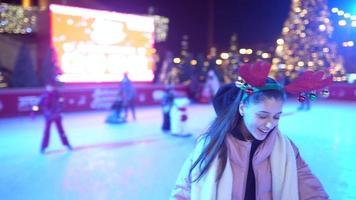 People enjoy ice skating in the street around Christmas tree in rink. photo