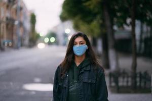 Young woman, person in protective medical sterile mask at empty street photo