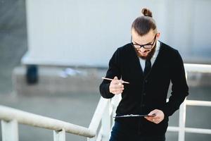 hombre de negocios se para con documentos en la mano foto