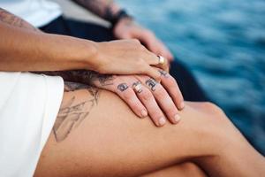 una pareja joven está sentada en el muelle junto al mar foto