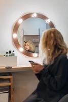 Attractive woman at the mirror in beauty studio photo