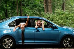 Two girlfriends fool around and laughing together in a car photo