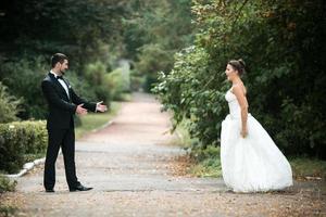 Beautiful wedding couple standing opposite each other photo